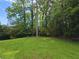 Lush backyard with vibrant green grass and mature trees offers a private and serene outdoor space at 2821 Ne Meadowlark Trail, Duluth, GA 30096