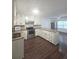 Bright kitchen features white cabinets, granite countertops, stainless steel appliances, and modern wood flooring at 2821 Ne Meadowlark Trail, Duluth, GA 30096
