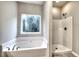 This primary bathroom features a shower, a large tub, and a window for natural light at 335 Melody Ne Ln, Cartersville, GA 30121