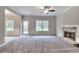 Spacious living room featuring a stone fireplace, large windows, and plush carpeting, creating a cozy and inviting atmosphere at 335 Melody Ne Ln, Cartersville, GA 30121