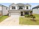 Charming two-story home boasts a pristine lawn, two-car garage, and welcoming front porch at 4720 Dufour Dr, Lilburn, GA 30047