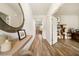 Inviting hallway featuring wood floors, a large decorative mirror, and an open entryway to another room at 4720 Dufour Dr, Lilburn, GA 30047