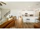 Open concept living space features wood floors, stairs, and kitchen with white cabinetry at 4720 Dufour Dr, Lilburn, GA 30047