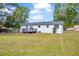 A white house with a gray deck and a spacious, fenced backyard with an expansive lawn at 2657 John Petree Rd, Powder Springs, GA 30127