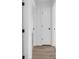Bright hallway featuring hardwood floors, white doors, and neutral walls at 2657 John Petree Rd, Powder Springs, GA 30127