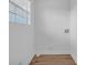 Bright laundry room featuring wood-look flooring, white walls, and a window for natural light at 2657 John Petree Rd, Powder Springs, GA 30127