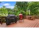 Spacious wooden back deck with barbecue and outdoor dining set amid lush green trees at 3349 Concord Se Cir, Smyrna, GA 30080