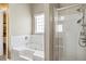 Bright bathroom featuring a garden tub, walk-in shower, and tiled walls at 3385 Amhurst Pkwy, Atlanta, GA 30349