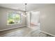 Dining room featuring wood floors, contemporary lighting, and a sunny window view at 3385 Amhurst Pkwy, Atlanta, GA 30349