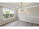 Bright dining room with wood floors, modern chandelier, and large window at 3385 Amhurst Pkwy, Atlanta, GA 30349