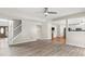 Open-concept living area with staircase, hardwood floors and connecting view into kitchen at 3385 Amhurst Pkwy, Atlanta, GA 30349