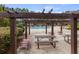 View of the community pool area featuring lounge chairs, picnic tables, and a covered pergola at 3385 Amhurst Pkwy, Atlanta, GA 30349