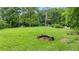 Expansive backyard featuring a well-maintained lawn, mature trees, a fire pit, and ample space for activities at 12728 Bells Ferry Rd, Canton, GA 30114