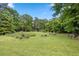 Lush backyard with a garden, mature trees, and ample space for outdoor activities at 12728 Bells Ferry Rd, Canton, GA 30114