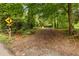 Long, tree-lined driveway leading to a private property, marked by a street sign and house number at 12728 Bells Ferry Rd, Canton, GA 30114
