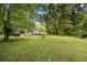 Expansive front yard with mature trees and green lawn, offering a serene and inviting approach to the home at 12728 Bells Ferry Rd, Canton, GA 30114