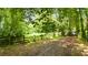 Gated entrance leading to a private property, surrounded by lush greenery and mature trees at 12728 Bells Ferry Rd, Canton, GA 30114