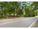 Street view of property featuring driveway leading to the home, surrounded by trees at 12728 Bells Ferry Rd, Canton, GA 30114