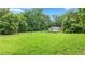 Large grassy yard featuring trees, ready for gardening or other outdoor activities at 12728 Bells Ferry Rd, Canton, GA 30114