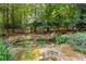 Backyard pond featuring lush greenery and rock border at 220 Broadmoor Dr, Fayetteville, GA 30215