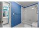 Bathroom with a shower/tub, a toilet, and bold blue patterned wallpaper at 220 Broadmoor Dr, Fayetteville, GA 30215