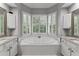 Bathroom featuring a soaking tub, tile flooring, and plantation shutters for privacy and light control at 220 Broadmoor Dr, Fayetteville, GA 30215