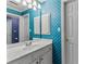 Bathroom with a white vanity, storage, and light blue patterned wallpaper at 220 Broadmoor Dr, Fayetteville, GA 30215