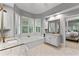 Bright bathroom featuring a soaking tub, a white tile floor, and a double vanity at 220 Broadmoor Dr, Fayetteville, GA 30215