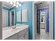 Bright bathroom with a white vanity, storage, and colorful wallpaper at 220 Broadmoor Dr, Fayetteville, GA 30215
