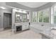 Well-lit bathroom features a soaking tub, double vanity, white cabinetry, and plantation shutters at 220 Broadmoor Dr, Fayetteville, GA 30215