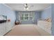 Spacious light blue bedroom with a daybed, dresser, and large window at 220 Broadmoor Dr, Fayetteville, GA 30215