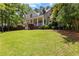 Two-story house featuring a covered porch, manicured lawn and mature trees at 220 Broadmoor Dr, Fayetteville, GA 30215
