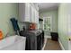Well-lit laundry room featuring a utility sink, modern washer/dryer, and ample storage cabinets at 220 Broadmoor Dr, Fayetteville, GA 30215