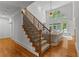 Elegant staircase with wood and iron railing, hardwood floors, and a view of the living room and high windows at 220 Broadmoor Dr, Fayetteville, GA 30215