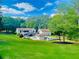 Expansive backyard with lush greenery, in ground pool, and pool house with outdoor kitchen at 345 Etheridge Rd, Auburn, GA 30011