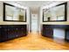 Dual-sink bathroom with large mirrors, dark wood cabinets, and wood flooring at 345 Etheridge Rd, Auburn, GA 30011