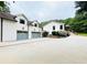 Exterior view of a home with a three car garage and well manicured landscaping at 345 Etheridge Rd, Auburn, GA 30011