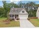 Charming single Gathering home featuring a covered front porch, two-car garage, and manicured lawn at 520 Edgemore Rd, Canton, GA 30114