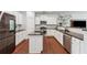 Well-equipped kitchen boasts white cabinets, a functional island, stainless steel appliances, and modern fixtures at 520 Edgemore Rd, Canton, GA 30114