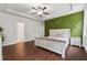 Main bedroom with hardwood floors, an accent wall, and a tray ceiling at 520 Edgemore Rd, Canton, GA 30114