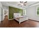 This primary bedroom features hardwood floors, an accent wall, and bright, natural light at 520 Edgemore Rd, Canton, GA 30114