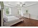 Primary bedroom boasts a tray ceiling, ceiling fan, and hardwood flooring at 520 Edgemore Rd, Canton, GA 30114