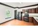 View of the kitchen featuring hardwood floors, dark cabinets, and black appliances at 6895 Slate Stone Se Way # 3, Mableton, GA 30126