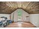 Finished attic space featuring wood paneling, natural light, and exterior door access at 7212 Avalon Dr, Douglasville, GA 30135