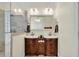 Bathroom with a double sink vanity with storage, framed mirror, bright lighting, and a glass enclosed shower at 7212 Avalon Dr, Douglasville, GA 30135