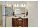 Bathroom with a double sink vanity with storage, framed mirror, bright lighting, and a glass enclosed shower at 7212 Avalon Dr, Douglasville, GA 30135