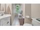 Bathroom with a vanity sink, toilet, white tile flooring, and a window providing natural light at 7212 Avalon Dr, Douglasville, GA 30135