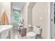 Bathroom with a vanity sink, toilet, white tile flooring, and a window providing natural light at 7212 Avalon Dr, Douglasville, GA 30135