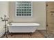 Luxurious bathroom featuring a standalone tub with glass-block window at 7212 Avalon Dr, Douglasville, GA 30135