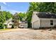 View of the home with driveway and detached two-car garage and lush surrounding trees at 7212 Avalon Dr, Douglasville, GA 30135